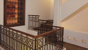 A staircase with ornate metal railings and a decorative window with intricate patterns. - Riad "LA DOUIRIA" in exclusivity (Marrakech)