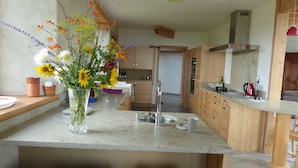 Une cuisine moderne avec un îlot central, des meubles en bois et un vase de fleurs.
