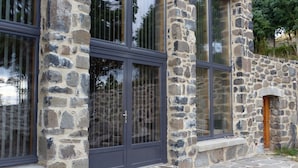 Un bâtiment en pierre doté de grandes fenêtres et d’une entrée en pierre.