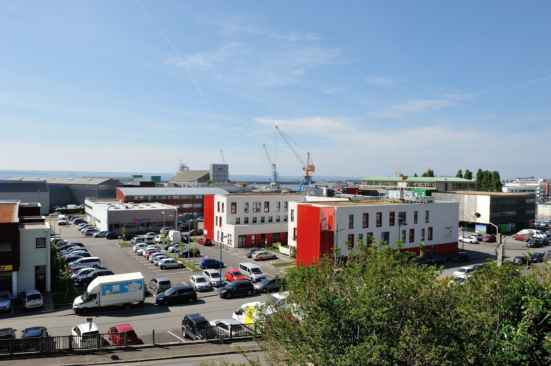 A parking lot with multiple cars and a white van.