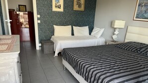 A hotel room with a bed, bedside table, and a wardrobe.