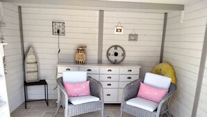 A cozy room with wicker chairs, a white dresser, and a small table. - QUIET, COMFORTABLE PROVENCAL FARMHOUSE IN THE COUNTRYSIDE WITH SECURE SWIMMING POOL (Cheval-Blanc)