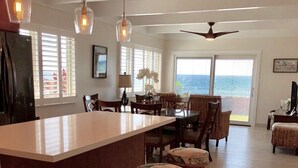 Cozinha espaçosa com ilha central, banquetas e iluminação pendente.