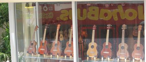 A store window with multiple ukuleles displayed on shelves.