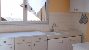 A kitchen with white cabinets, a sink, and a window.