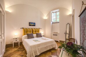 Une chambre à coucher avec un lit, une table de chevet, une fenêtre et un miroir.