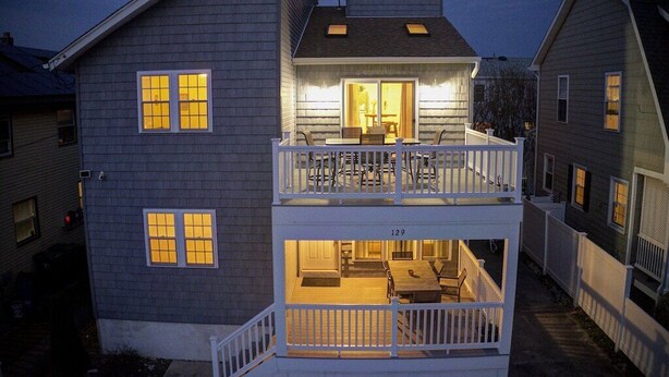Een tweelaags huis met een balkon en een eethoek.
