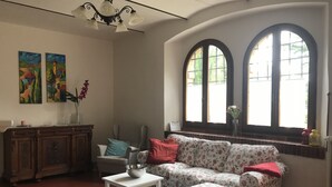 Ein Wohnzimmer mit einer Couch, einem kleinen Tisch, einem Schrank und zwei Bildern an der Wand.