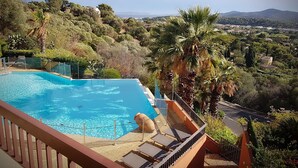 Une piscine offrant une vue sur la ville et les collines en arrière-plan.