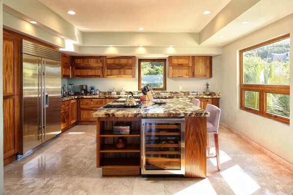 A modern kitchen with a large island, built-in appliances, and ample natural light.