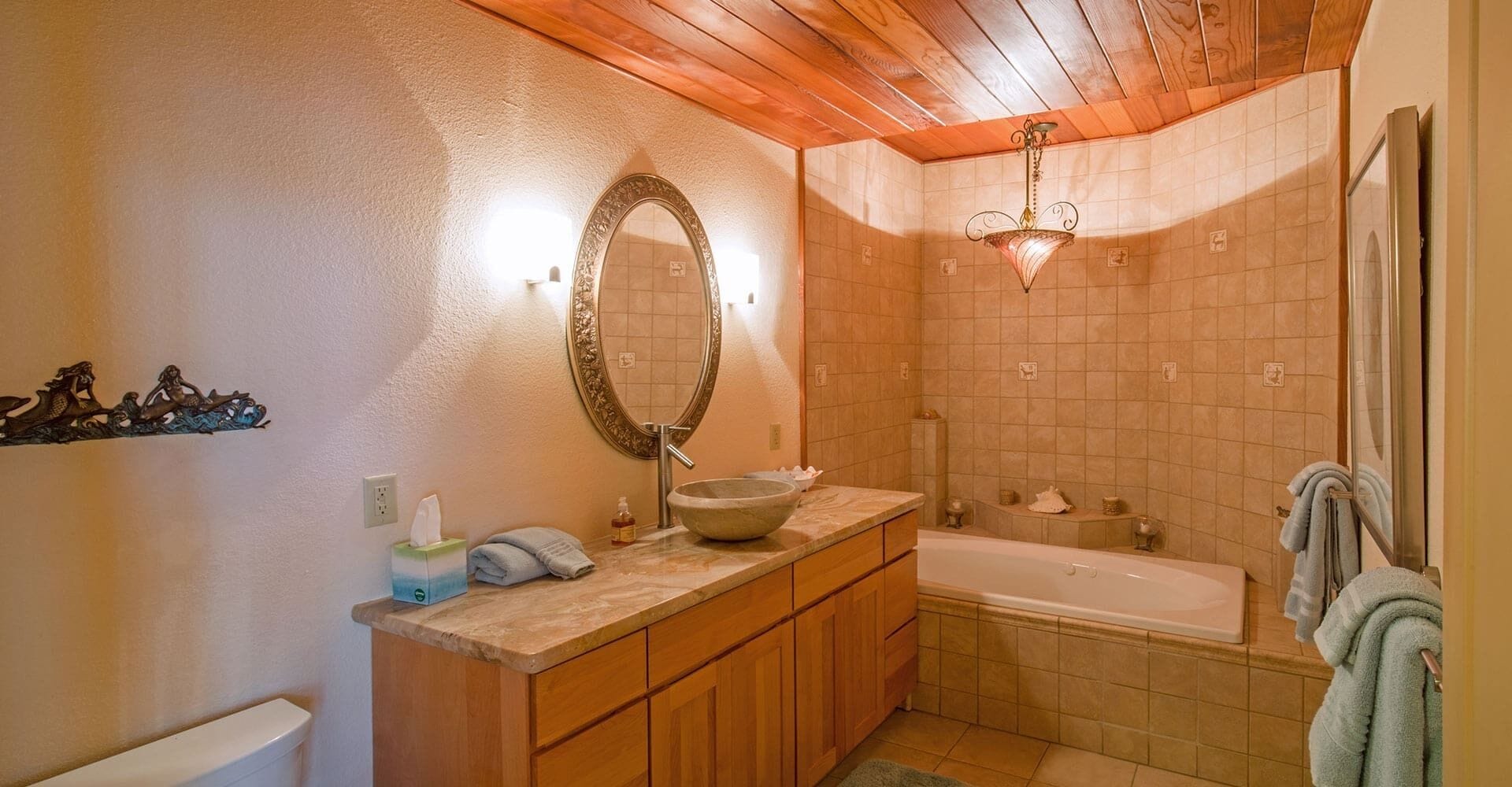 Un baño con tocador de madera, un espejo grande, una bañera y zona de ducha.