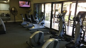 A gym with stationary bikes, treadmills, and a television on the wall. - True DIRECT Oceanfront - Admiral's Row 305 - Right on the Beach!  Best View! (Hilton Head Island)