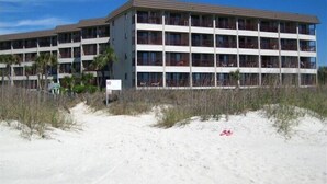 A multi-story hotel with a flat roof and balconies, located near a sandy beach. - True DIRECT Oceanfront - Admiral's Row 305 - Right on the Beach!  Best View! (Hilton Head Island)