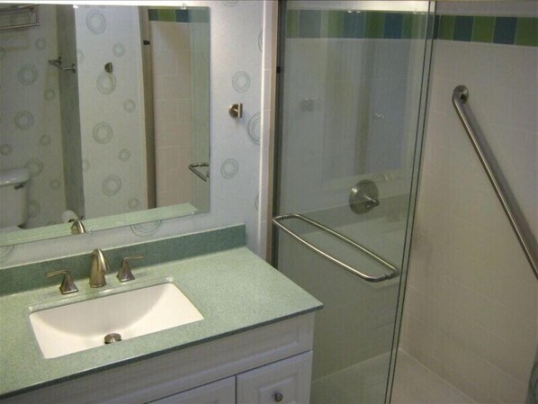 A bathroom with a sink, mirror, and glass shower enclosure. - True DIRECT Oceanfront - Admiral's Row 305 - Right on the Beach! Best View! (Hilton Head Island)