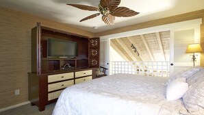 A bedroom with a bed, a TV on a wooden cabinet, a ceiling fan, and a window with blinds. - Quiet, Private Paradise M208 steps to the tropical pool and tennis court (Kihei)