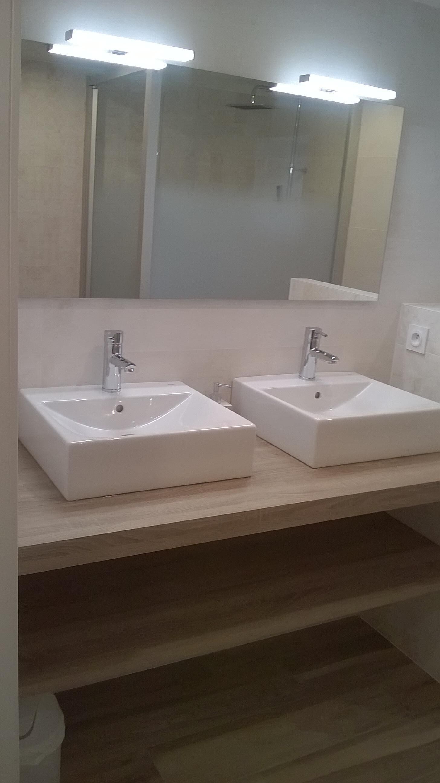 A bathroom with two white sinks and a large mirror above them.