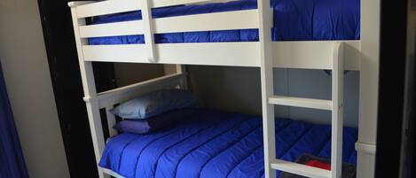 A bunk bed with blue bedding and a pillow.
