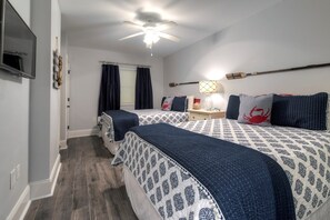 A bedroom with two beds, a ceiling fan, a TV, and a lamp. - Blue Haven- Ocean Front Condo at Mar Vista Grande Summer Specials Available! (North Myrtle Beach)