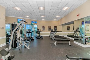 A gym with cardio machines, weight equipment, and mirrors.