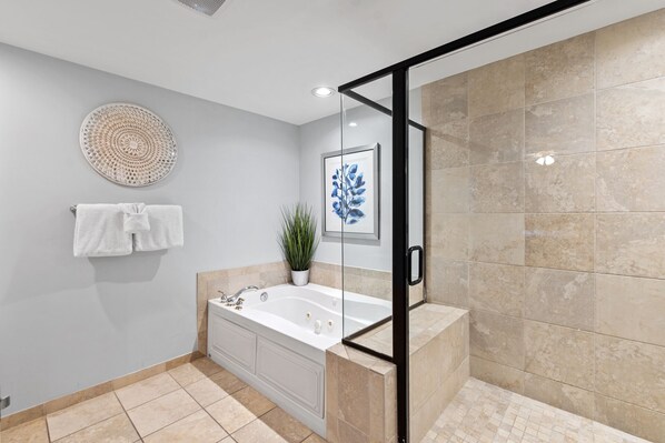 A modern bathroom with a glass-enclosed shower, a bathtub, and a potted plant. - Blue Haven- Ocean Front Condo at Mar Vista Grande Summer Specials Available! (North Myrtle Beach)