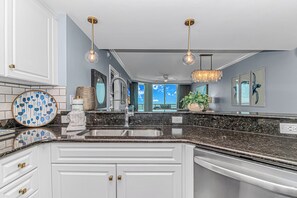A modern kitchen with a central island, stainless steel appliances, and pendant lighting. - Blue Haven · Direct Oceanfront 3BR, Sleeps 10, High Floor (North Myrtle Beach)