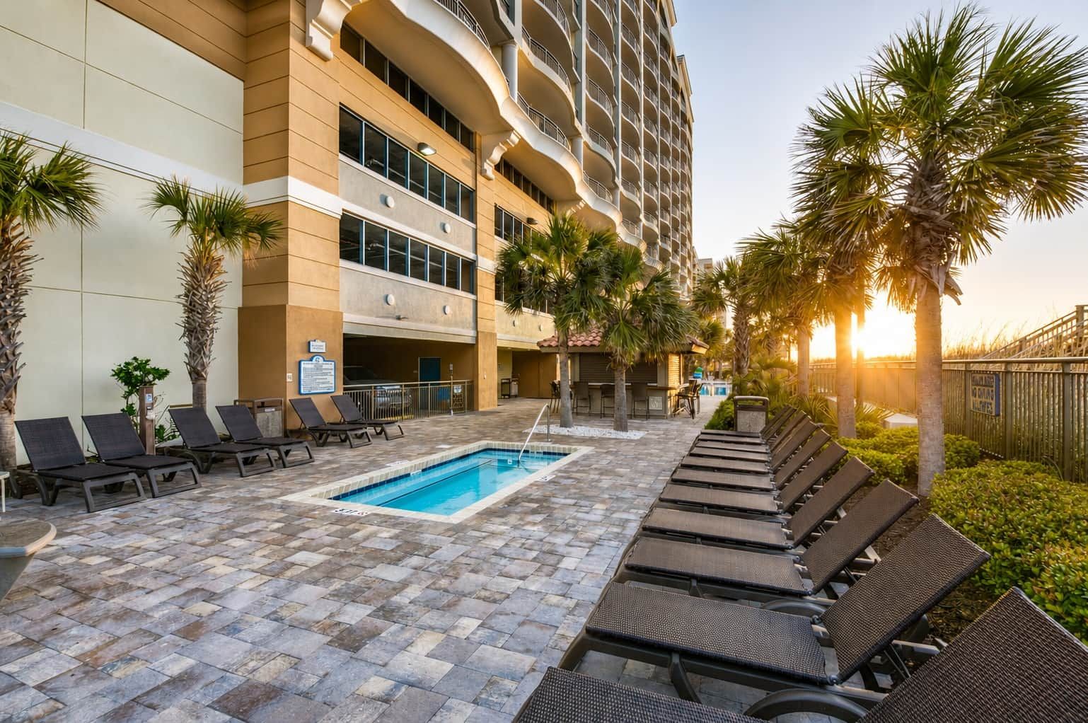 A hotel pool area with lounge chairs and a swimming pool.