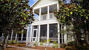 A two-story house with a balcony, large windows, and a front porch. - "The Lighthouse" in WaterColor. Pool, Walk to beach, 4 Bikes & WC amenities incl (Santa Rosa Beach)
