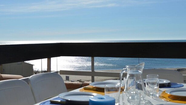 A table set for dining with a view of the ocean. - 3-room apt with terrace, AC, parking in Cap d'Agde, near beach and shops (Cap d'Agde)