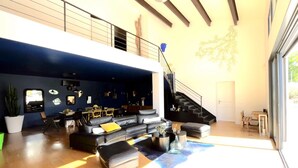 Una sala moderna con sofá, mesa de centro y una escalera.