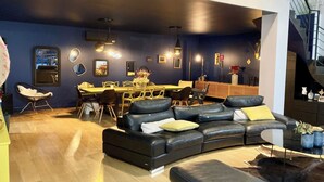 Una sala de estar moderna con un sofá modular, un comedor y una escalera.