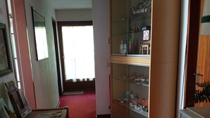 A room with a red carpet, a wooden cabinet with glass doors, and a refrigerator. - Pension Streng-Reinhardt (Ostfildern)