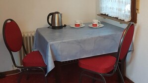 A dining area with a table set for two, a kettle, and two cups on saucers. - Pension Streng-Reinhardt (Ostfildern)