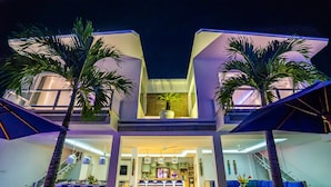 A modern, multi-level building with a central open space, a staircase, and a dining area. - Exclusive Private 8 Bedroom Estate, 2 Huge Pools, Seminyak (Seminyak)