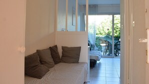 A narrow hallway with a bed on the left and a door on the right. - Studio Cabine 3 Couchages à 50m de la Plage avec Terrasse et Parking - Le Grau d'Agde (Le Grau d'Agde)