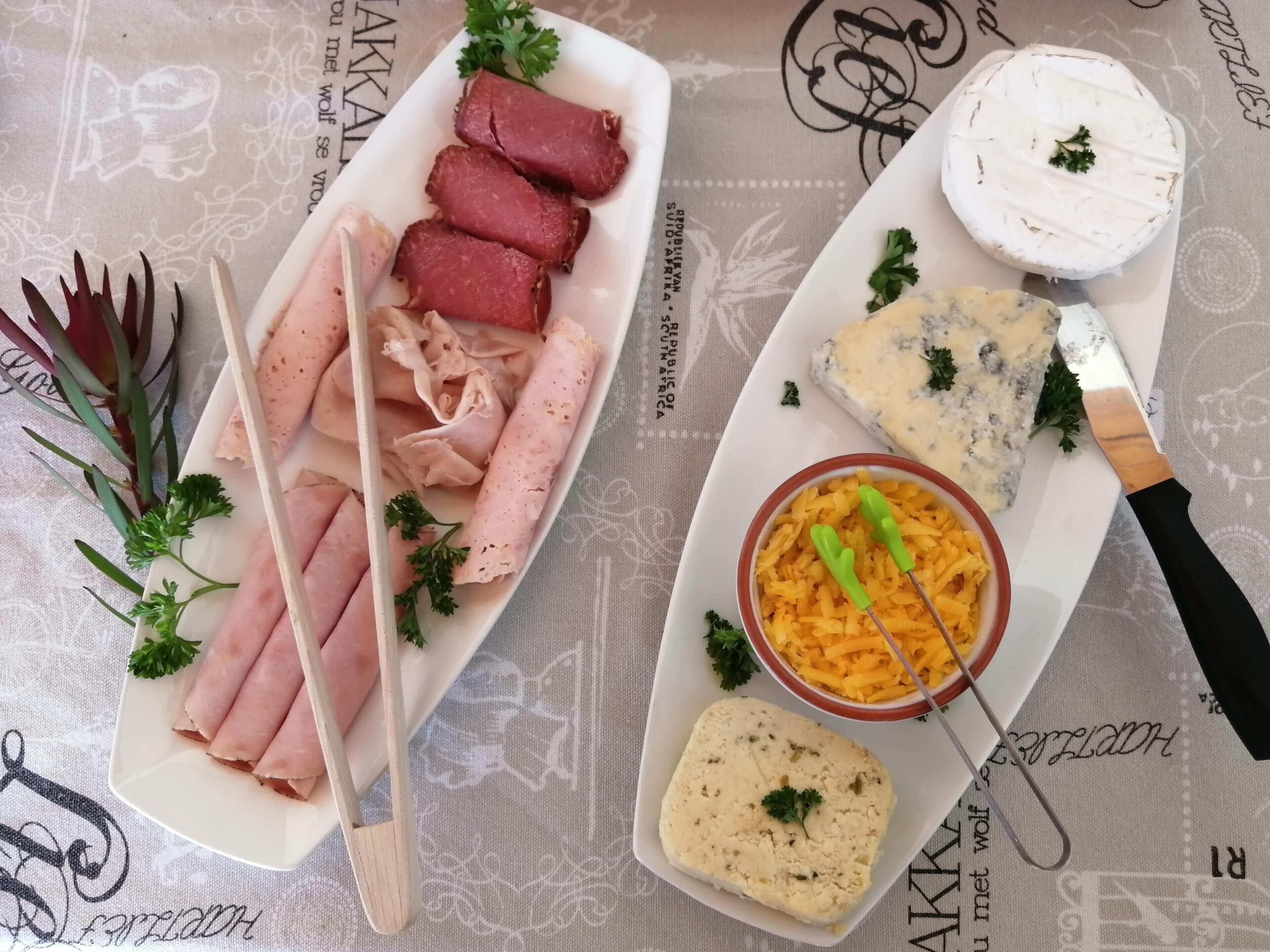 A variety of food items including sliced meats, cheese, and a bowl of rice.