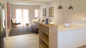 Een moderne keuken met een centraal eiland, houten planken en hanglampen.