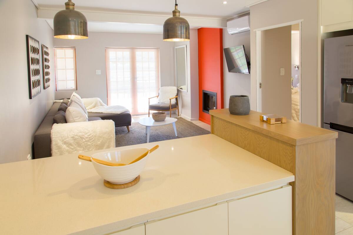 A modern kitchen with a white countertop, a large bowl, and a refrigerator.