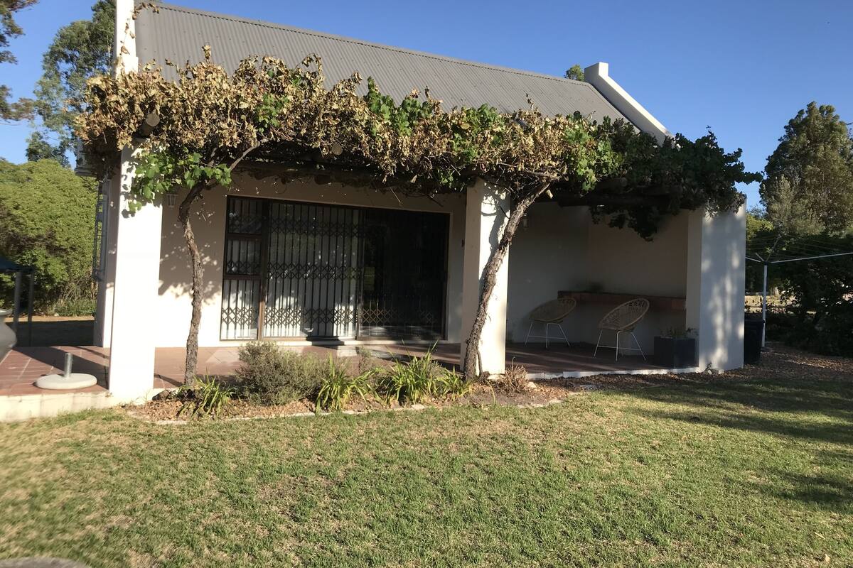 A house with a covered porch, a metal gate, and a small garden area.