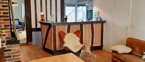 Une cuisine moderne dotée d’un îlot central, d’un plancher en bois et d’un mur en briques.