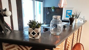 Un plan de travail de cuisine agrémenté d’une plante en pot, d’un bocal en verre et d’une boîte décorative.