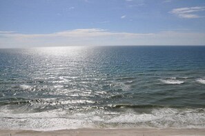 A beach with waves and a clear sky.