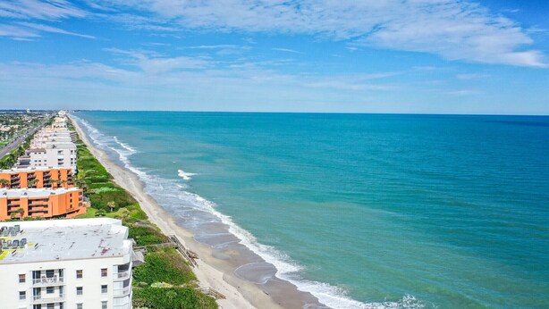 Vista costera con playa, océano y edificios a lo largo de la orilla.