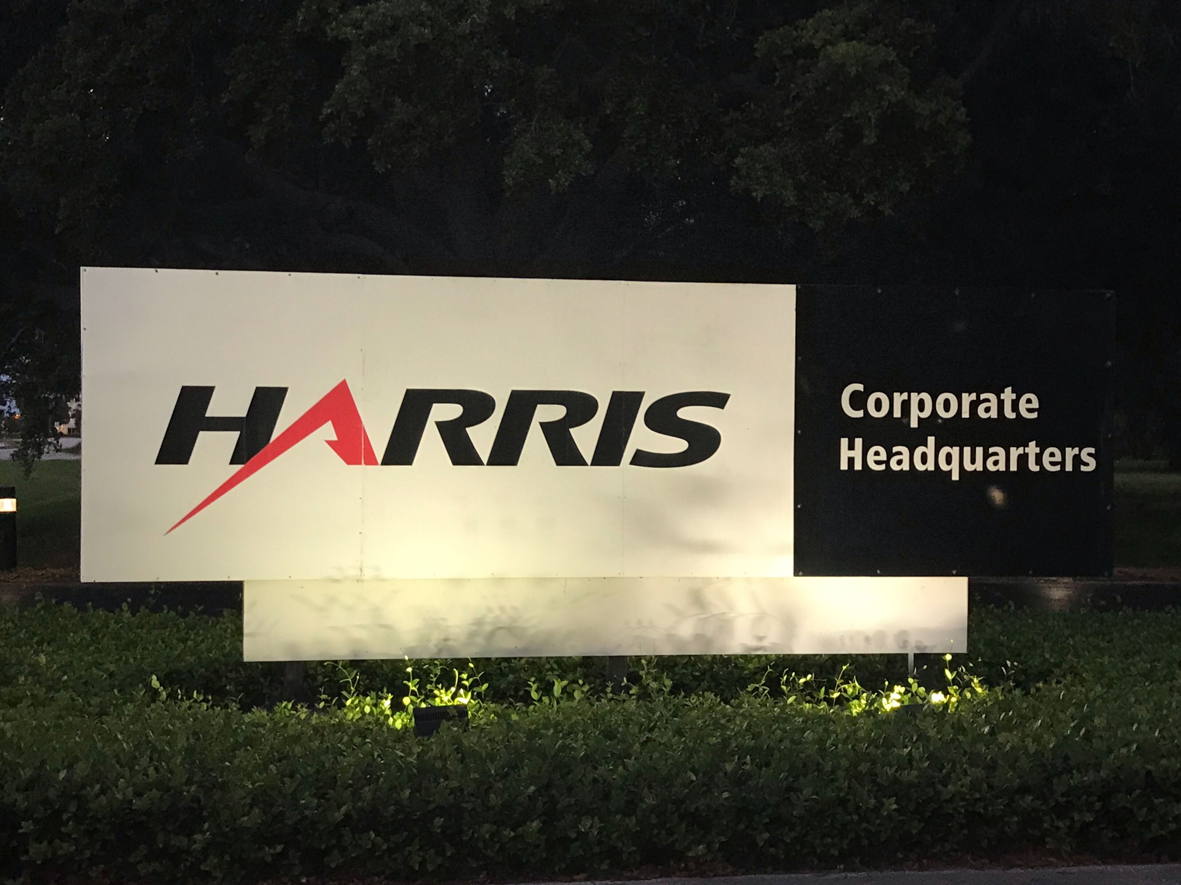 A sign for Harris Corporate Headquarters with a red arrow graphic.