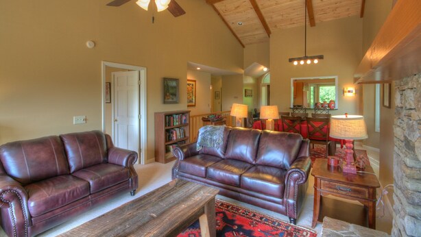 A spacious living room with leather sofas, a wooden coffee table, and a ceiling fan. - Townhome w/ Mtn Views & Club Access! Indoor Pool, Near Blowing Rock & Skiing (Boone)