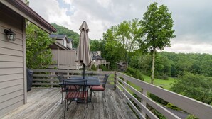 A wooden deck with a table and chairs, a covered umbrella, and a view of a forested area. - Townhome w/ Mtn Views & Club Access! Indoor Pool, Near Blowing Rock & Skiing (Boone)