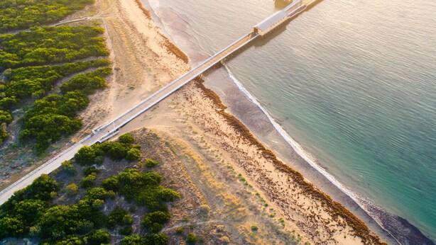 Vue aérienne d’une zone côtière avec un pont qui enjambe l’eau.
