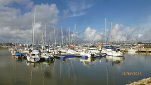 Een jachthaven met verschillende boten afgemeerd, kalm water en een heldere lucht.