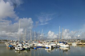 A marina with multiple boats docked, calm water, and a clear sky. - COMFORTABLE APARTMENT 1 BEDROOM - 2/4 PEOPLE (LAGOS)
