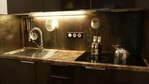 A modern kitchen with a stainless steel sink, a kettle, and a coffee machine. - Saint Paul De Vence, Charming Suites in The Heart Of The Village. 4 ** Biloba (Saint-Paul-De-Vence)