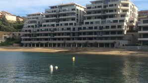 Een hotel met meerdere verdiepingen en balkons, nabij een strand.